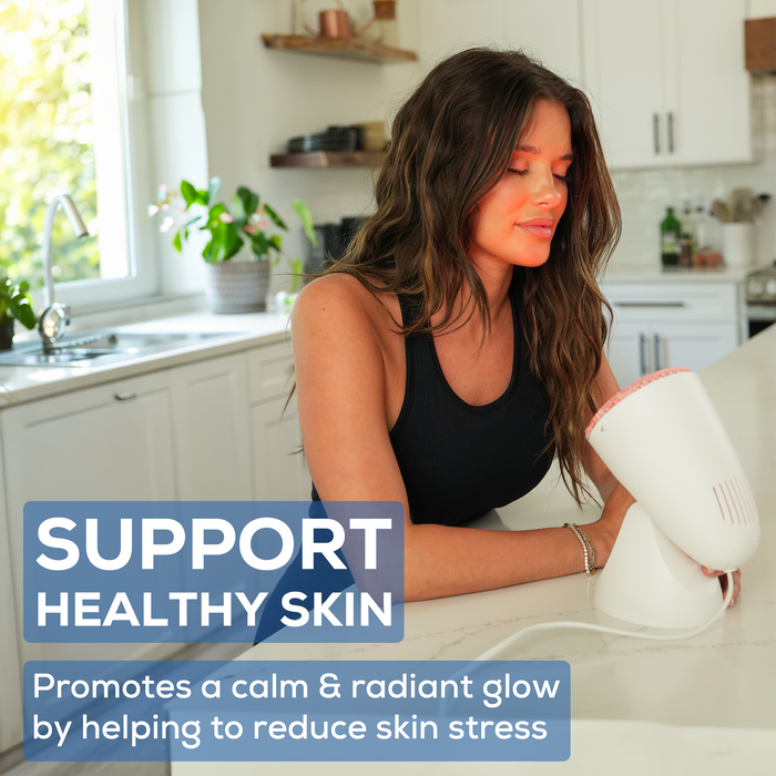 A woman stands at the counter, eyes closed, and facing IL11. IL11 is treating her face to boost skin appearance and support a radiant glow. 